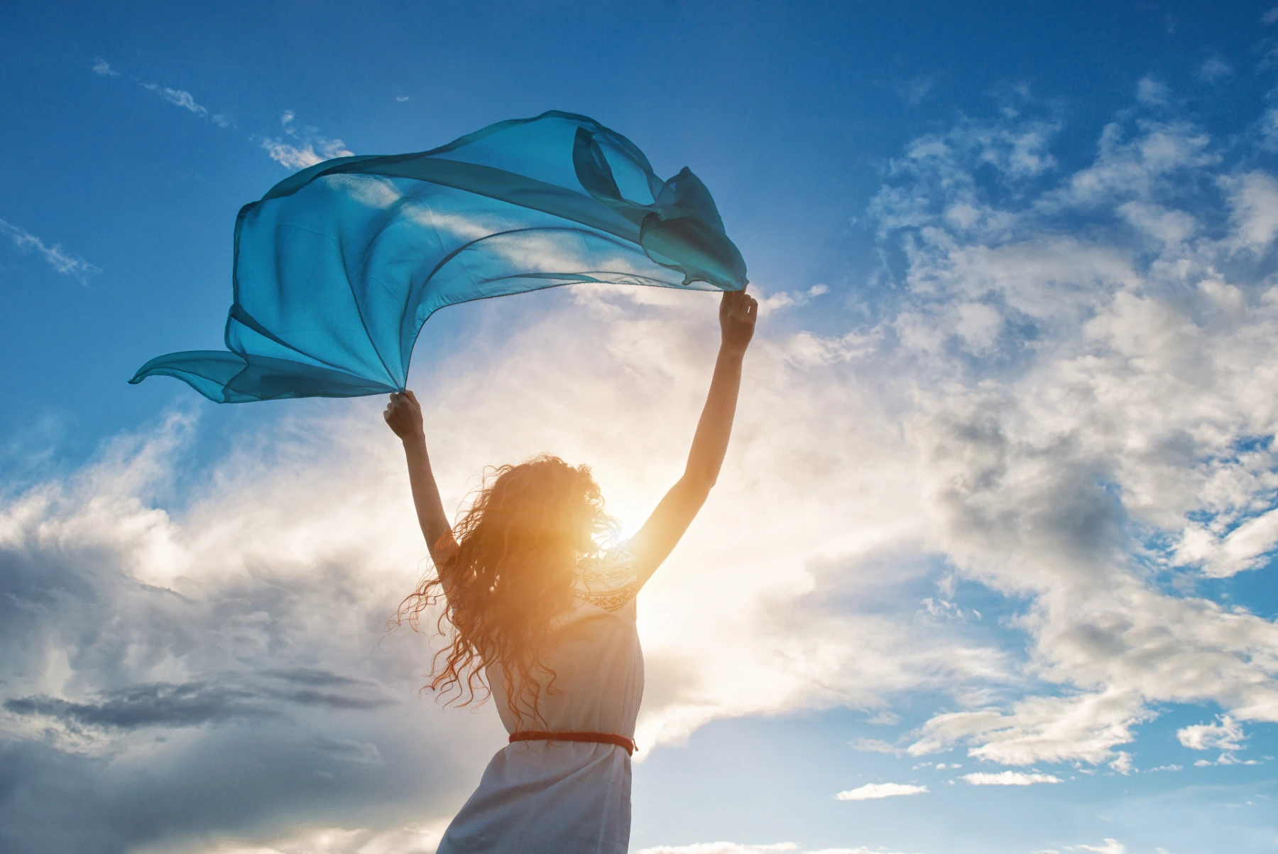 woman with a blue scarf on a beach